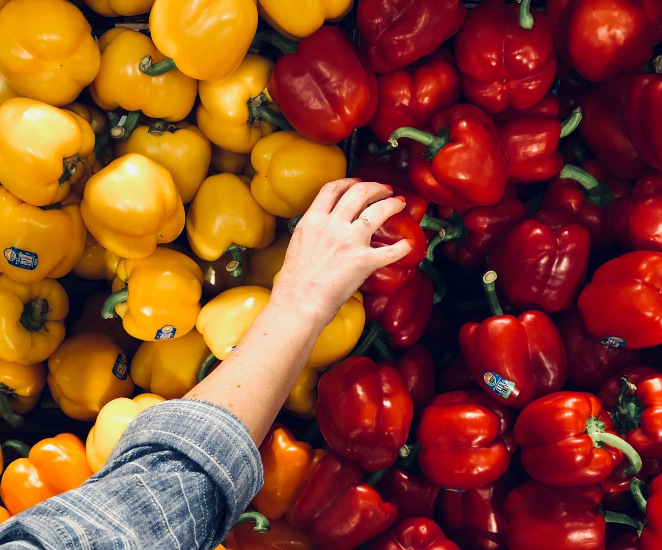 hand reaching for bell peppers in dauphin island store