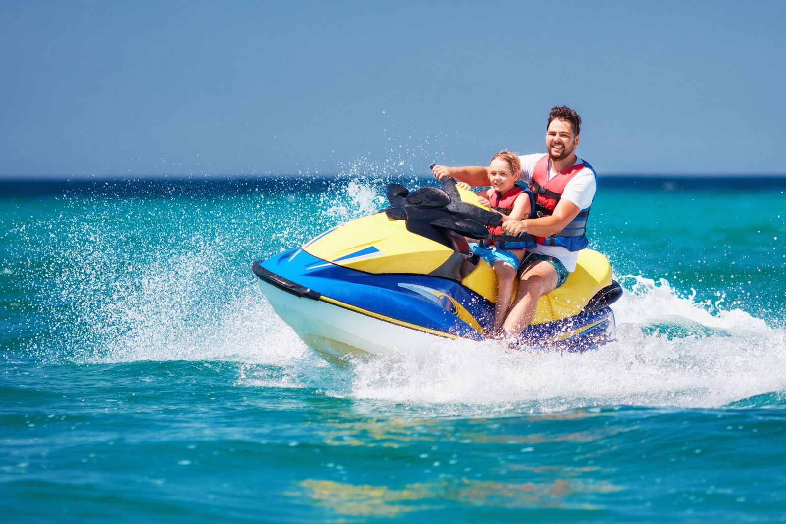 father and son on a jet ski
